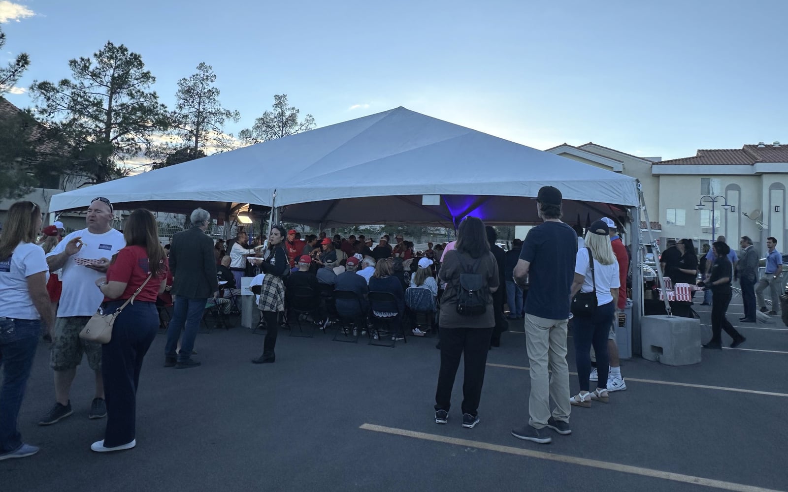 Guests gathered inside and around the white outdoor event tent in a Las Vegas parking area